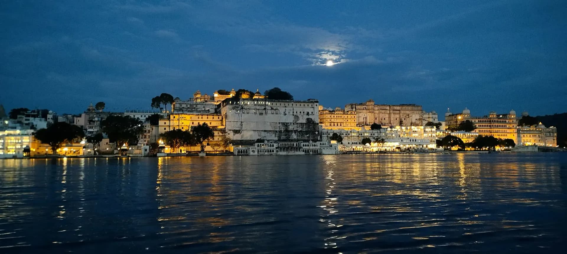 Udaipur City Palace at night, viewed across Lake Pichola