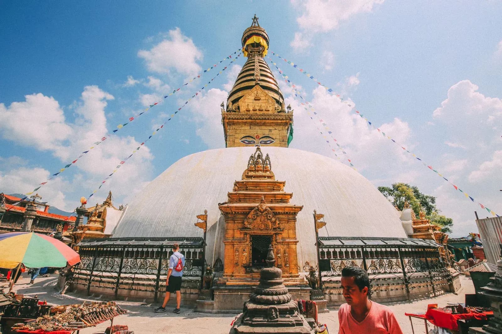 Swayambhunath Stupa's golden spire and painted Buddha eyes, strung with prayer flags