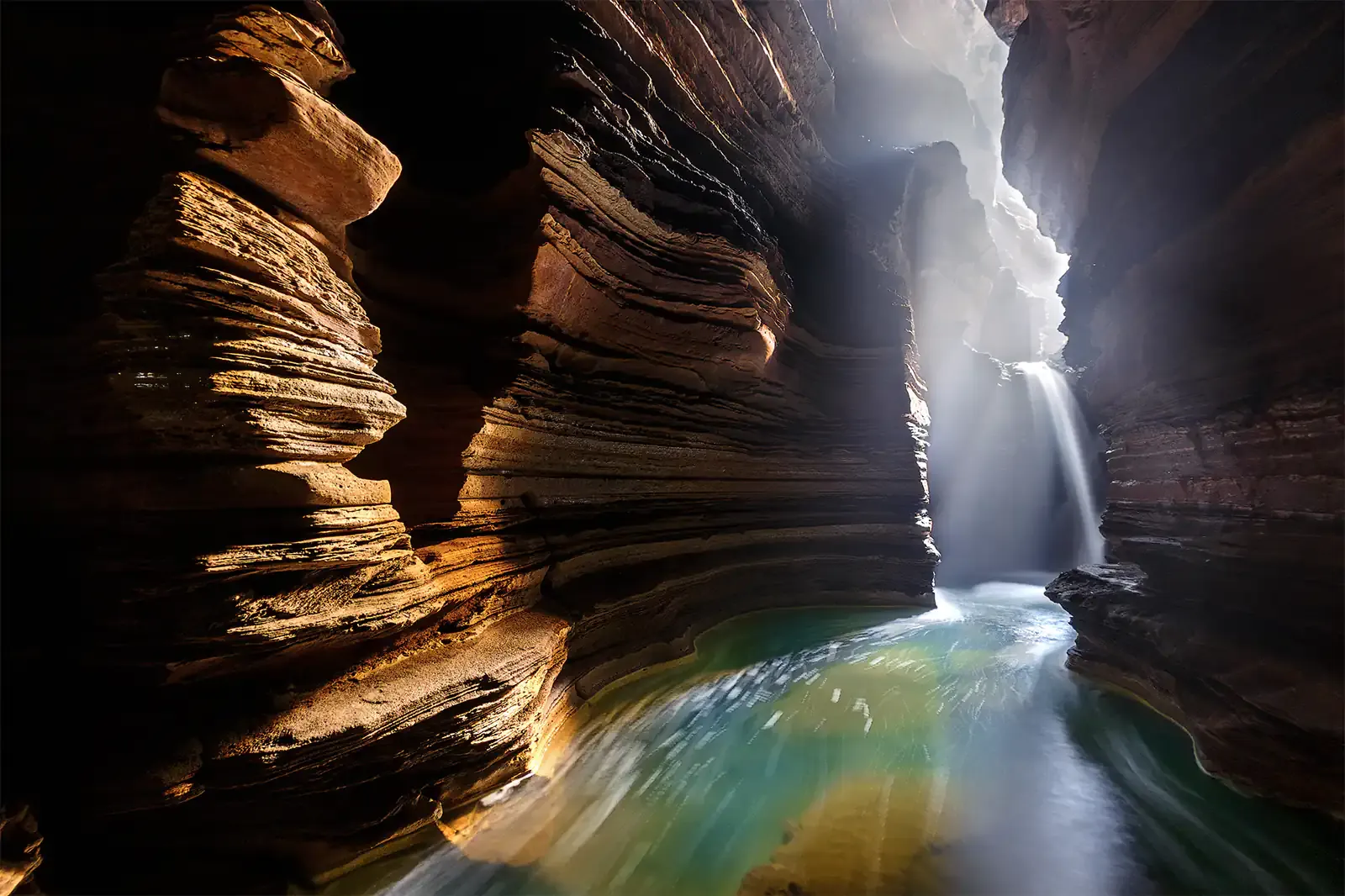 The underground waterfall inside Gupteshwor Cave, lit by a shaft of daylight