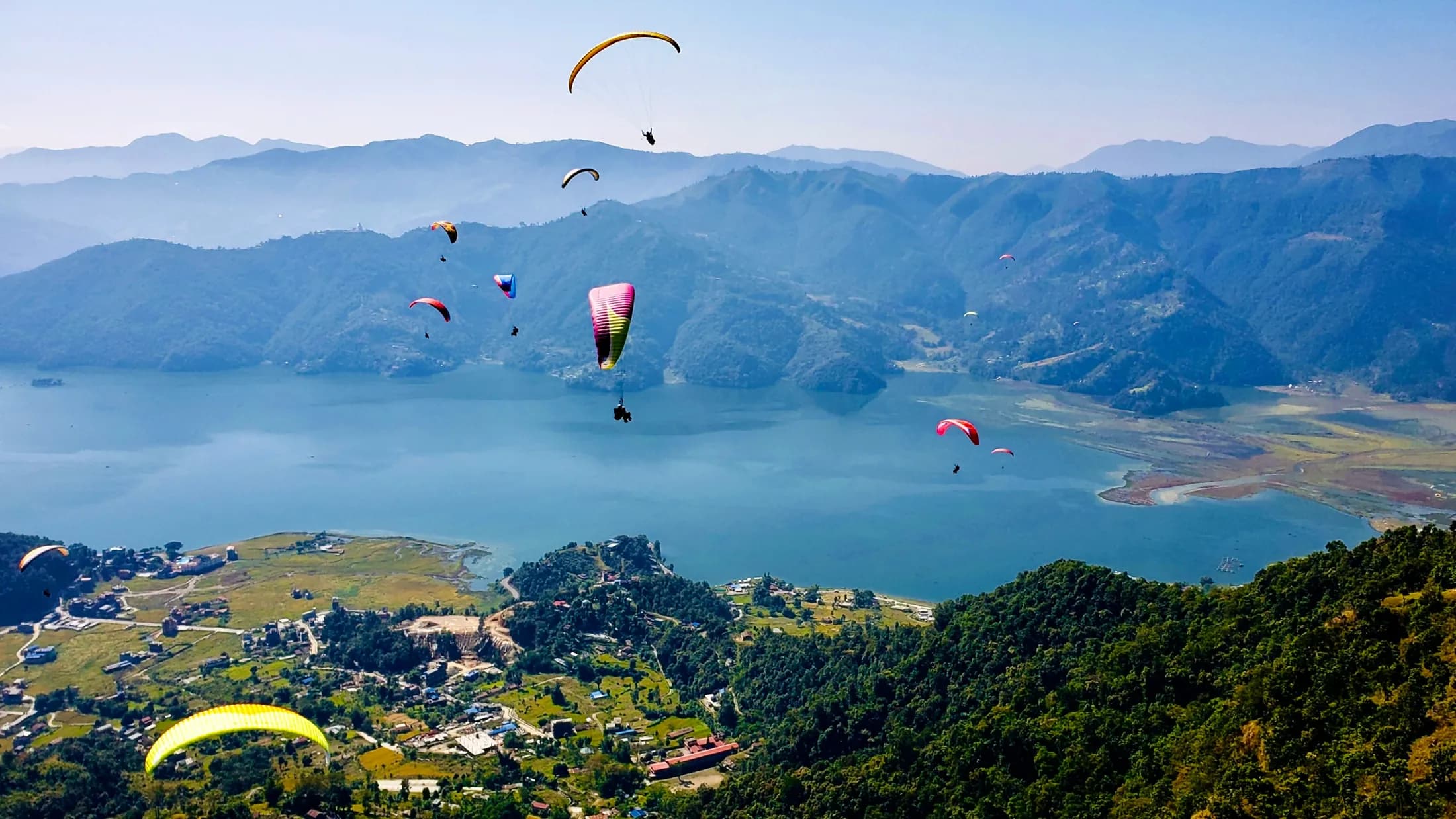 Paragliders drifting over Phewa Lake above Pokhara