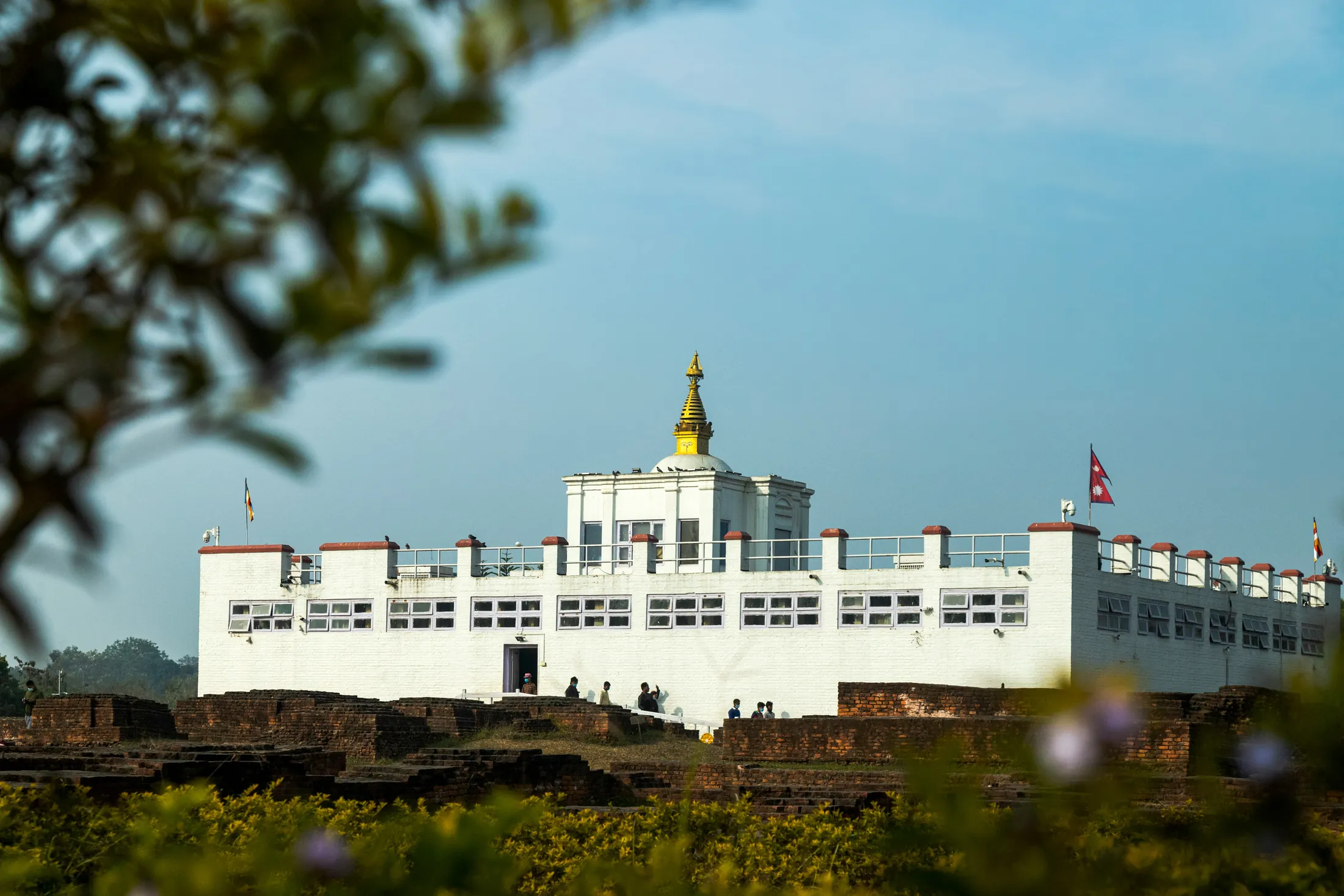 The white Maya Devi Temple building rising above the excavated brick ruins at Lumbini