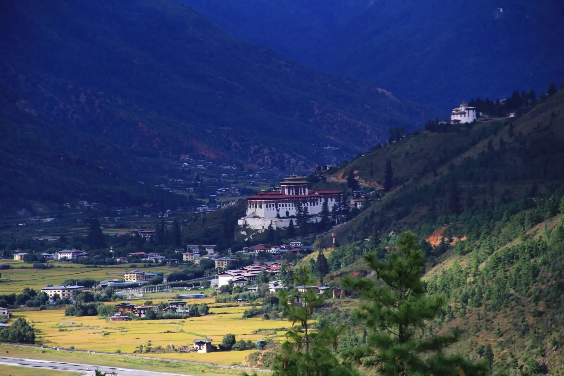 Rinpung Dzong on its ridge above the Paro valley, with the airport runway below