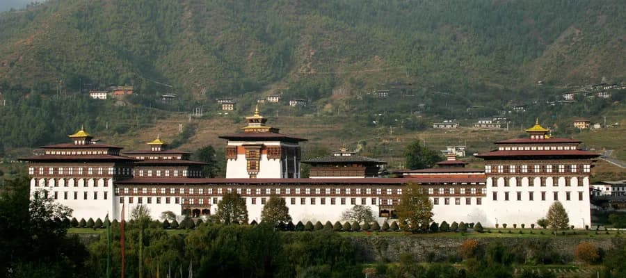 Tashichho Dzong's whitewashed walls and golden roofs against the hillside
